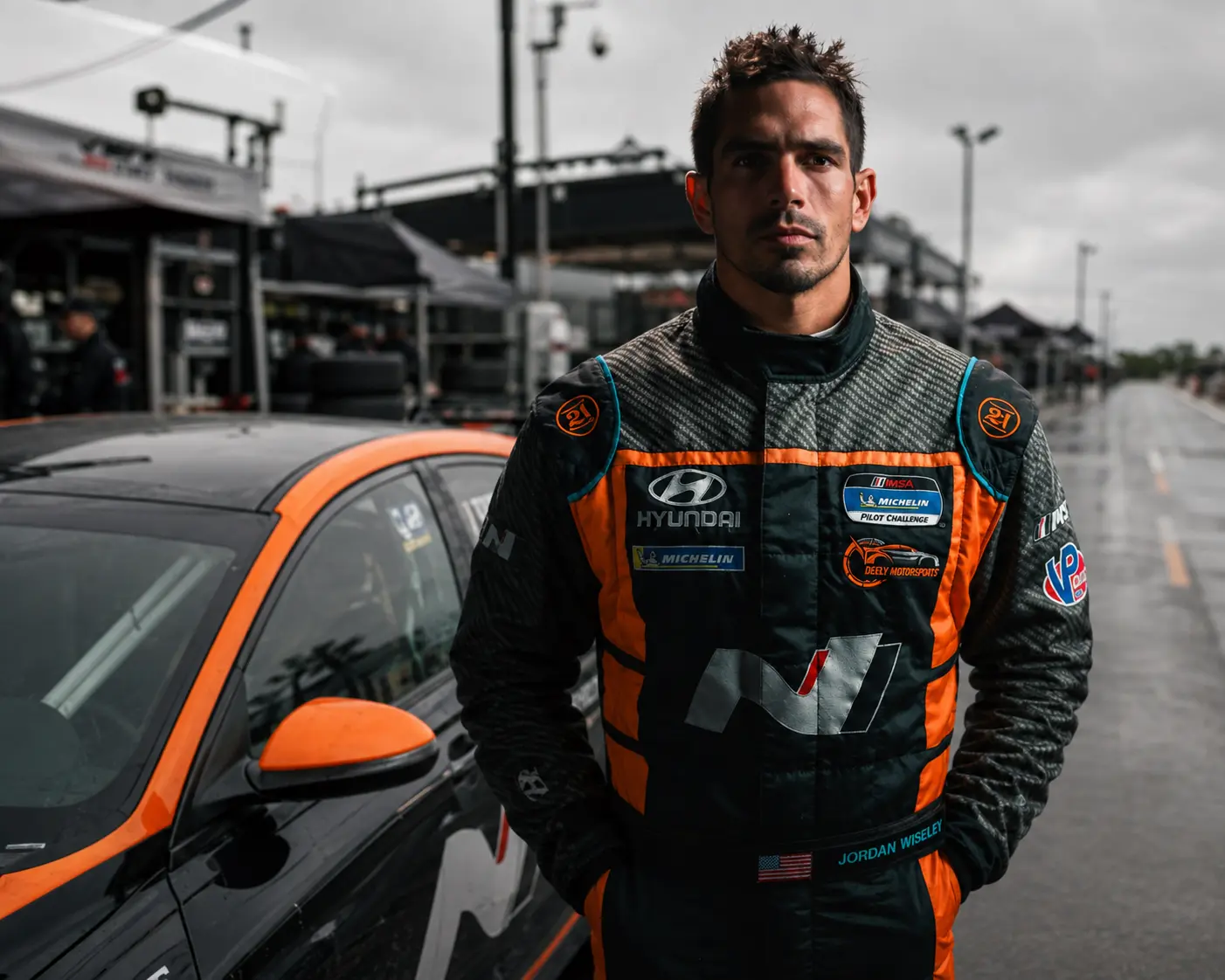 Jordan Wiseley in racing gear at a professional road-course paddock